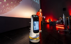KettyBot service robot displaying content on screen near an event stage. Service robot at an Äripäev business conference in Estonia